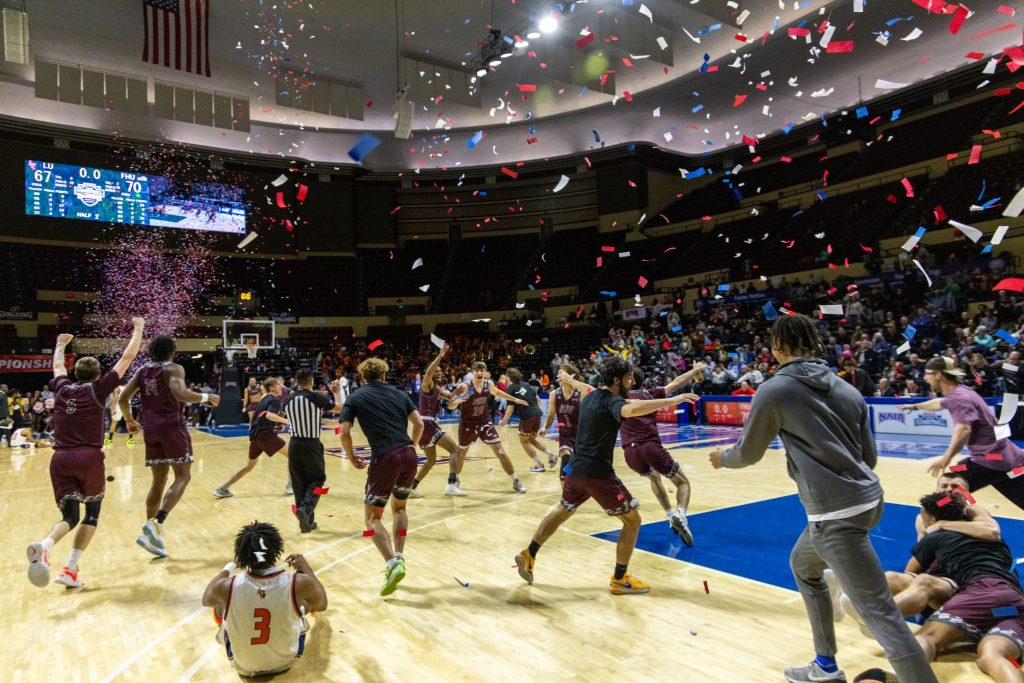 The Freed-Hardeman University Lions celebrate after winning a men's basketball national championship
