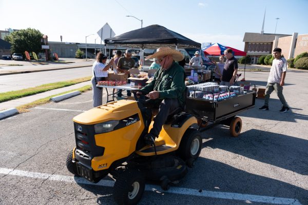 Carrol Harris Sr. hauls a trailer with drinks during the Bridgewood Church of Christ's regular Saturday food giveaway. 