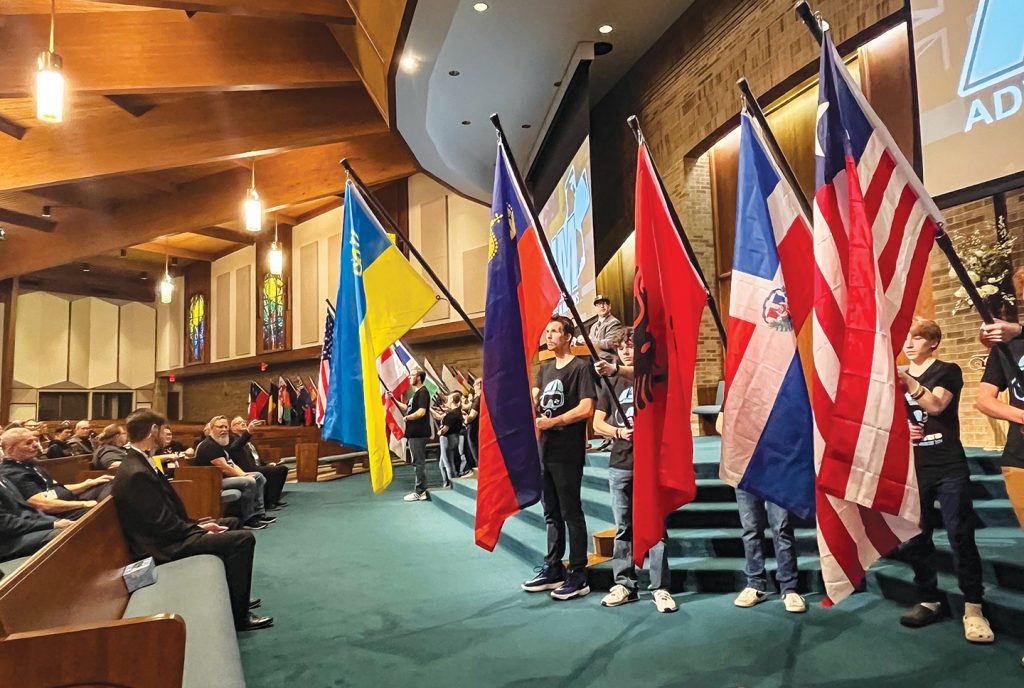 Students in the Adventures in Missions program hold flags from around the world as Sunset Vision Workshop participants pray for the nations.