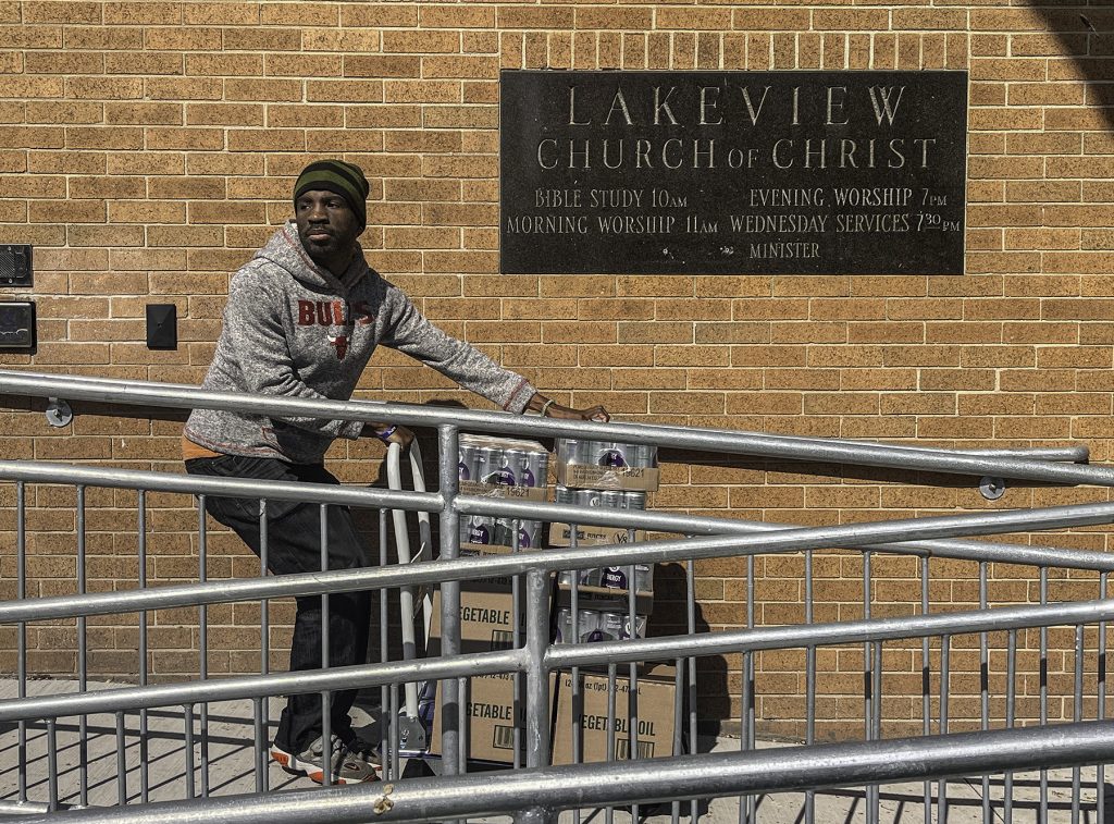 A volunteer carts donated food up the wheelchair ramp for the Lakeview Church of Christ's food ministry.