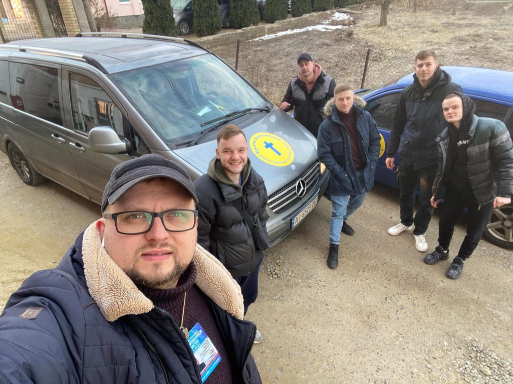 Dima Grischuk, left, and fellow drivers with the Let's Love ministry prepare for a journey to eastern Ukraine to distribute aid and to ferry back the displaced.